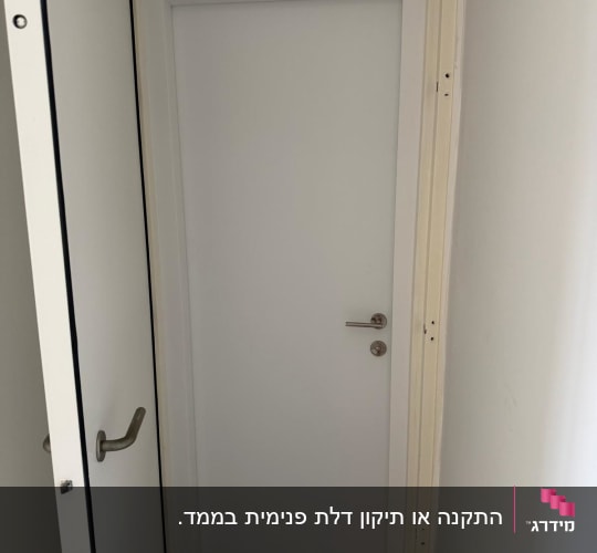 התקנת דלת פנים לבנה בתוך משקוף חדר ממ"ד